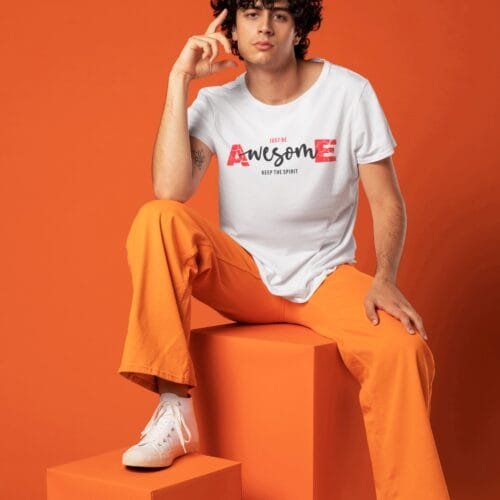 a man sitting on a cube having white tshirt with red text awesome